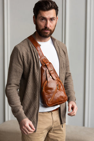A Stylish and Professional Man Standing with a yellow brown hip pack in a Contemporary Modern Setting.の写真素材