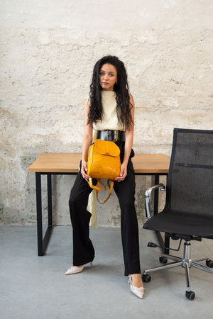 A Chic Outfit Featuring a Bright Yellow Backpack Paired with Stylish and Trendy Footwearの写真素材