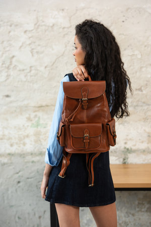 A Chic Outfit Featuring a Brown Backpack Paired with Stylish and Trendy Dress and Blue Shirtの写真素材