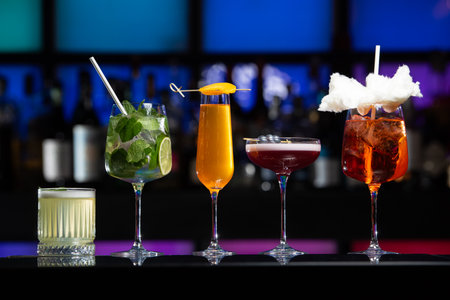 row of various colourfull alcoholic cocktails on a bar desk. Glasses of differen shapes. selective focusの写真素材