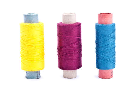 Three vintage paper multi colored thread coils on white background (blue, yellow and lilac)の写真素材
