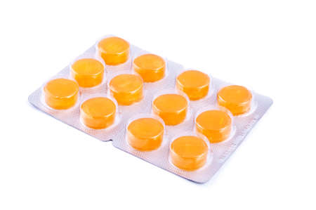 Close up of pack of yellow pills isolated on white backgroundの写真素材
