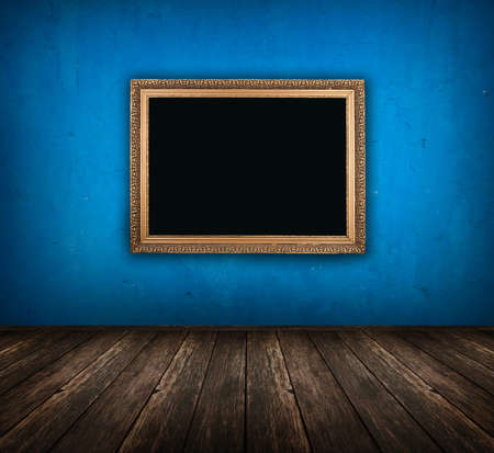 dark vintage blue room with wooden floor and golden frame hanging on the wallの写真素材