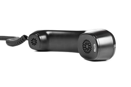 Black telephone receiver with cord on white backgroundの写真素材