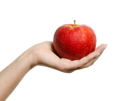 Beautiful female hand holding and showing a perfect red apple on white backgroundの写真素材