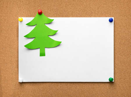 Christmas tree made of green paper and blank sheet on the cork boardの写真素材