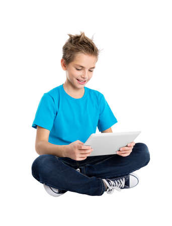 Boy sitting with digital tablet isolated on white backgroundの写真素材