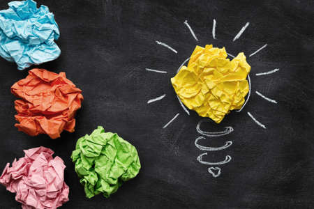 Idea concept, colorful crumpled paper on the blackboard turned into a light bulb