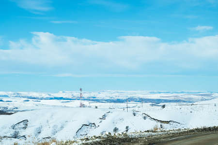 Photo from a mountain road with a view of the big sky and the mountain range in the distanceの写真素材