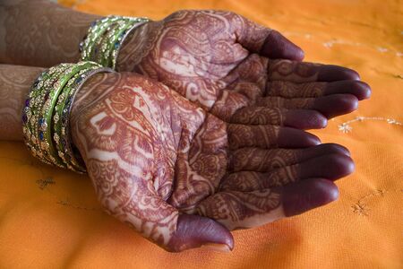 Hands of a Indian bride with henna design and banglesの写真素材