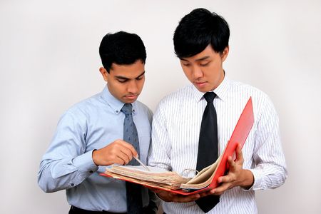 Indian and Chinese businessman looking at a file.の写真素材