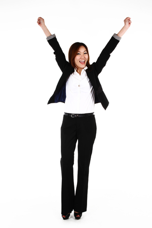Portrait of young Asian business woman celebrating a triumph with arms up, on white backgroundの写真素材
