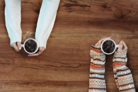 Female hands holding cups of coffeeの写真素材