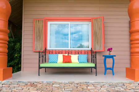 Retro bench outside small vacation house, colorful decorationの写真素材