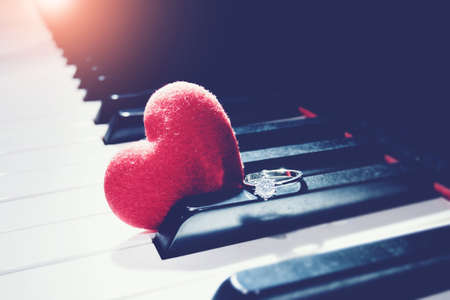 Ring and a hearts on piano ,vintage tone. Valentines Day background, wedding day. Love conceptの写真素材