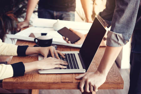 Group of young asia business people using laptop and mobile phone at meeting. Startup business concept.の写真素材