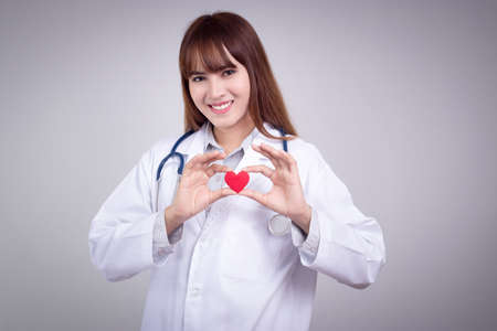 Healthy concept : Young Asian doctor with red heart in handの写真素材