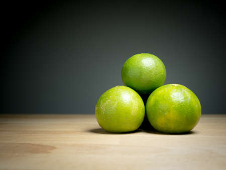 Close up green lemons on wooden tableの写真素材