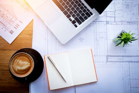 Abstract architectural drawing , sketch , plan background : architecture blueprint for detail of project and modern house on table in modern office with notebook , coffee , cactus ,laptop. film effectの写真素材