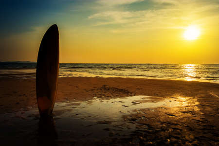 Surfing for water sport outdoor activity lifestyle concept. Silhouette of surfboard on the beach in sea shore at sunset time with beautiful light. water sport backgroundの写真素材