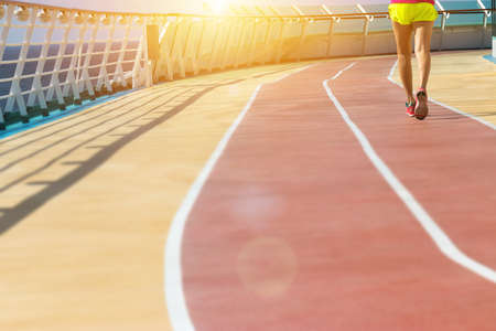 healthy vacation lifestyle. young fitness woman run on athlete running track at cruising boat. sport background の写真素材