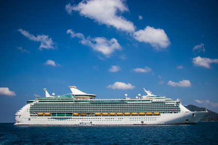 Luxury cruise ship sailing from port. Big cruise ship in the sea with beautiful blue sky background. Beautiful summer seascape poster for advertise. Holiday vacation lifestyle on cruise.の写真素材