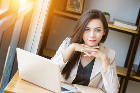 portrait of beautiful and confident Asian business woman in working age using computer laptop technology for manage job work, look at camera. businesswoman ,  girl power and International Womenâs Dayの写真素材