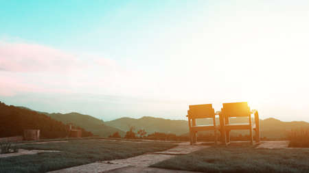 Two wooden comfortable chairs sitting in the yard facing a mountain nature view.の写真素材