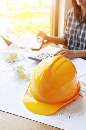 architect Asian woman working with laptop, calculator and blueprints. engineer calculate and inspection in workplace for blueprints architectural plan,sketching a construction project ,selective focusの写真素材