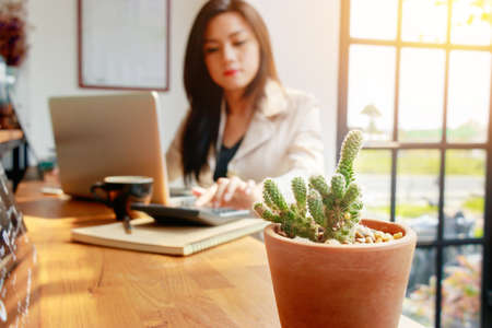 Asian business woman using calculator for accounting and analyzing investment in front of computer laptop at office workspace.  banking , savings , accountant , finances and economy concept.の写真素材