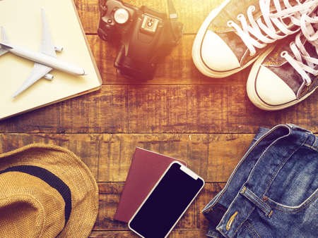 flat lay of passport , mobile , plane model , sneakers , camera and traveler's accessories items on...