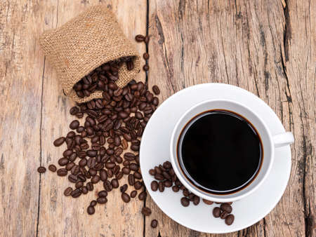 fresh espresso coffee cup with coffee bean on wooden table. coffee background for cafe or coffee...