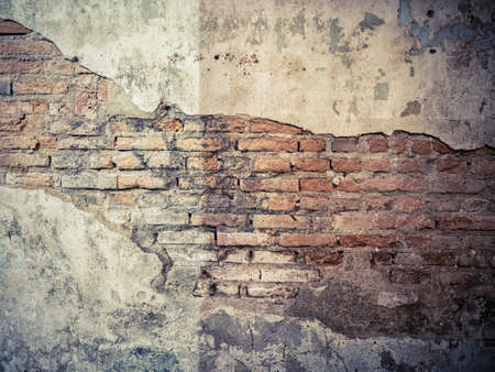 old crack concrete cement wall with red brick block inside. vintage background textureの写真素材