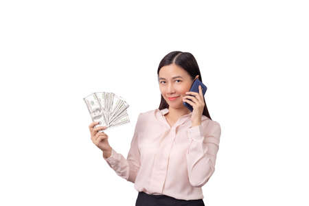 Asian beautiful woman holding banknote money in hand and mobile phone in another hand isolated on white background with clipping path.  commercial business by phone conceptの写真素材