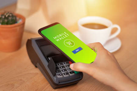 cashless Society, customer paying bill through smartphone using NFC technology in cafe. mobile digital wallet technology conceptの素材 [FY310124846024]