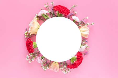creative layout made with fresh colorful spring flowers on bright pink background with white circle banner label. wedding invitation, posters or greeting designの写真素材