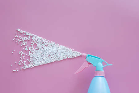 blue spray bottle spraying white bubble foam on pink background with copy space. creative minimal for cleaning conceptの写真素材