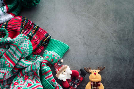 green sweater and red scotch blanket laying on the cement background with a Santa Claus doll and a reindeer for Christmas ornament with copy spaceの写真素材