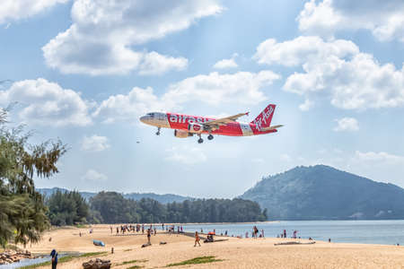 PHUKET, THAILAND - FEBRUARY 1, 2020: AirAsia aircraft ready for landing with many tourists visiting the plane landing spot and enjoy taking pictures of the plane at Mai Khao Beach, near Phuket Airportのeditorial素材