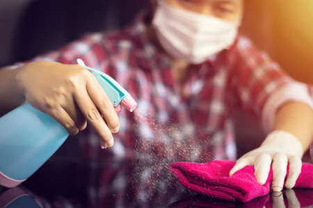 hand holding pink microfiber cleaning cloth and spray bottle with sterilizing solution make cleaning and disinfection for good hygiene, prevent spreading Coronavirus COVID-19 outbreakの写真素材