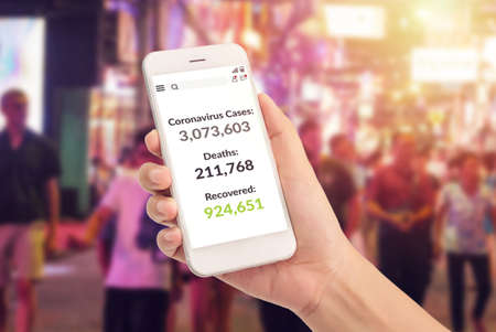 hand holding phone with covid-19 coronavirus pandemic statistic data updated on screen with number...
