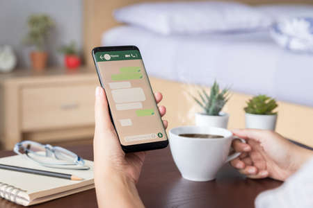 woman hand holding mobile smartphone with mockup screen of chat message on social media application....