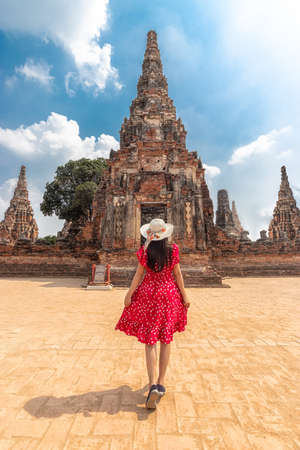 Asian tourist woman in red dress and sun hat from back view, walking through the beautiful history castle and historic temple at Ayutthaya, Thailand during vacation. travel after coronavirus lockdownのeditorial素材