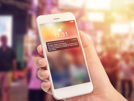 Coronavirus COVID-19 exposure notification apps concept. new notification message on smartphone screen to warning about high risk area to possible COVID 19 exposure via application on mobile phoneの写真素材