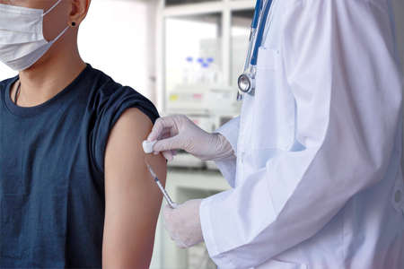 coronavirus COVID-19 vaccine concept. doctor hand holding needle syringe and vaccine bottle for...