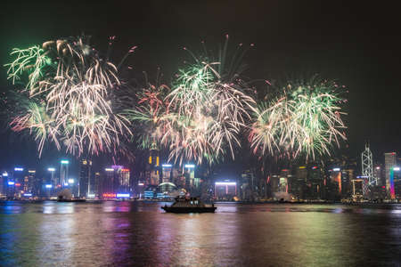 Hong Kong, Hong Kong - October 1 2015: Fireworks illuminate the sky above the famous Hong Kong skyline as viewed from Kowloon across the Victorial Harbour for China national day.のeditorial素材