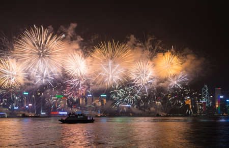 Hong Kong, Hong Kong - October 1 2015: Fireworks illuminate the sky above the famous Hong Kong skyline as viewed from Kowloon across the Victorial Harbour for China national day.のeditorial素材