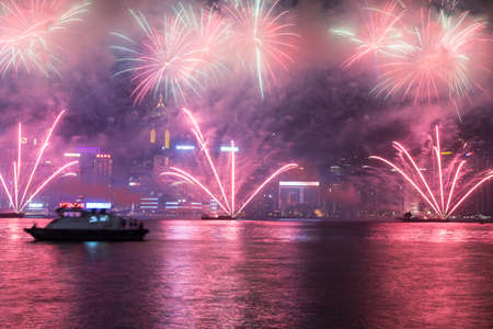Hong Kong, Hong Kong - October 1 2015: Fireworks illuminate the sky above the famous Hong Kong skyline as viewed from Kowloon across the Victorial Harbour for China national day.のeditorial素材
