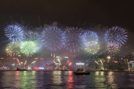 Hong Kong, Hong Kong - October 1 2015: Fireworks illuminate the sky above the famous Hong Kong skyline as viewed from Kowloon across the Victorial Harbour for China national day.のeditorial素材