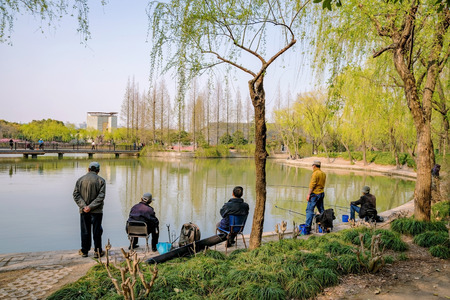 chinese people fishing on a lake in a park in Shanghaiの写真素材